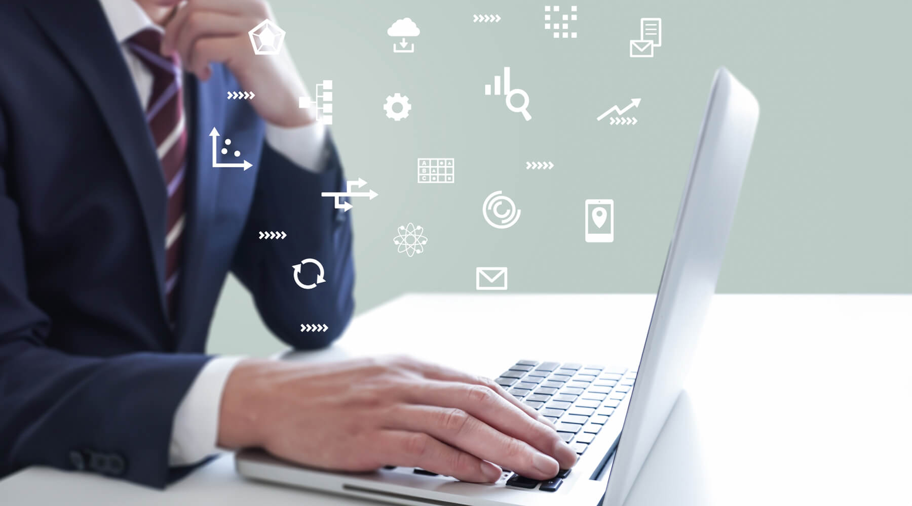 ビジネスマンがノートパソコンを使って様々なDX操作を行っている写真